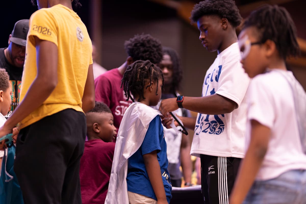 A boy receiving his academic cape at the ceremony