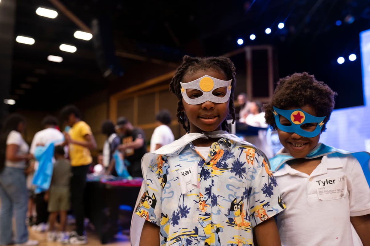 Two boys in capes and masks at the Cape Ceremony