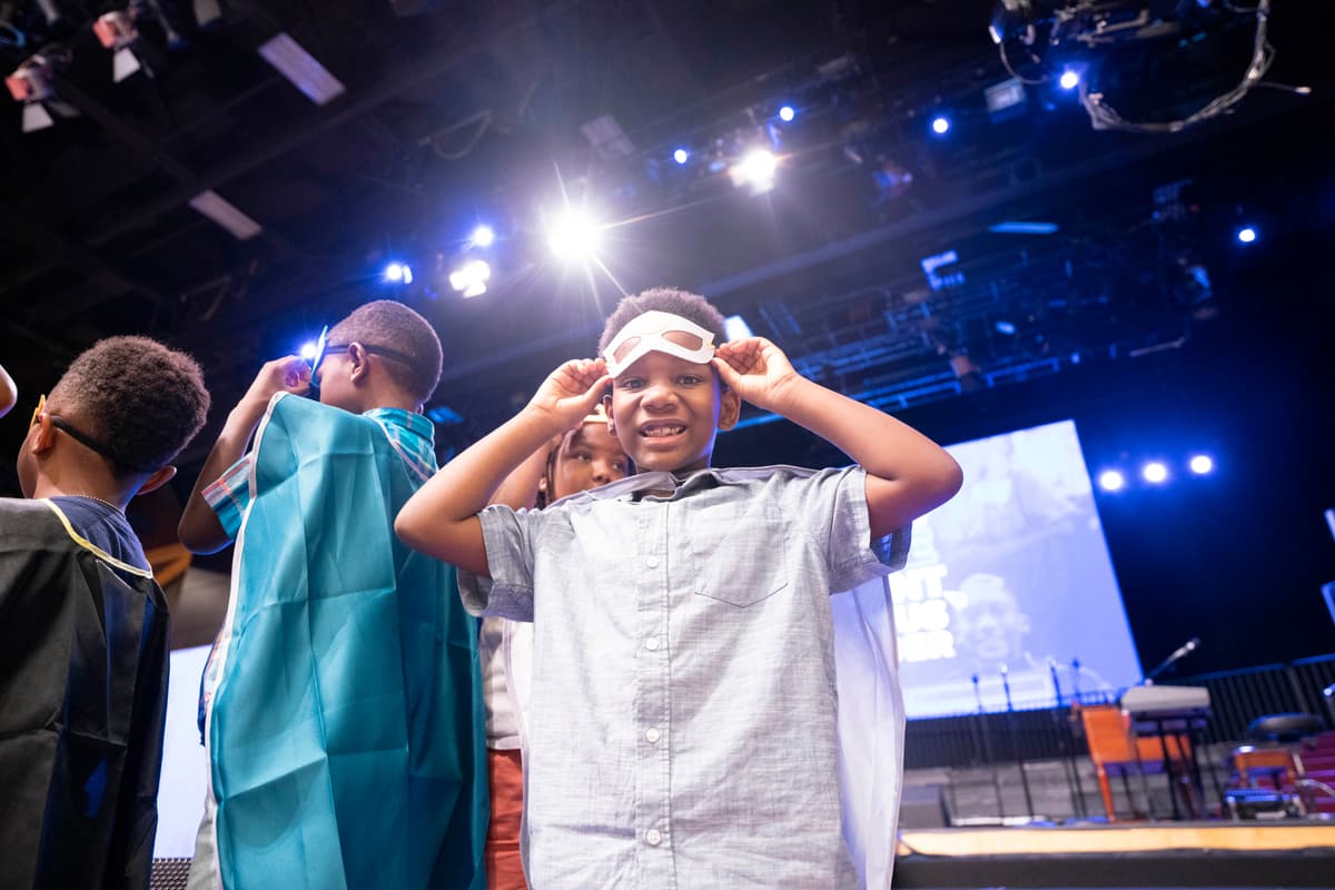 Boy putting on his superhero mask at the ceremony